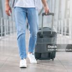 Air travelling concept. Man walking with luggage at airport corridor