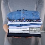Woman holding folded clothes in hands