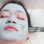 sleeping woman in clay mud facial mask on face on bed at night , Girl taking care of dry complexion. Beauty treatment