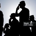 Several soldiers salute the flag at sunset during a military exercise. Army, Marines and Air Force were represented at the ceremony.