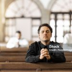 Prayer, religious and young man in church with congregation, faithful and hands together. Religion, male and worship in tabernacle for guidance, spiritual and support with closed eyes and praying