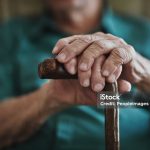 Cropped shot of an unrecognizable man leaning on his walking stick