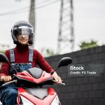 Mature woman driving a motorcycle in a parking